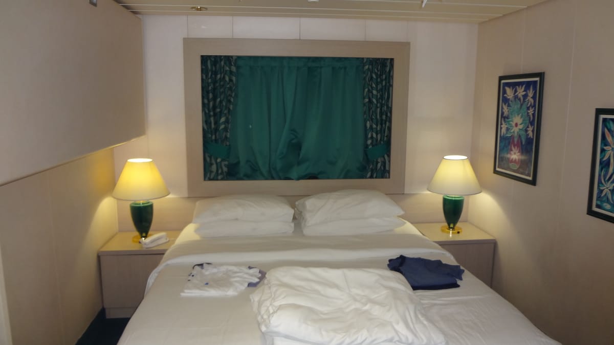 A standard cruise-ship cabin interior — the space the first-time packing list is built around.